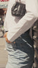 Woman styling a white long-sleeve tee with jeans while walking through New York City.