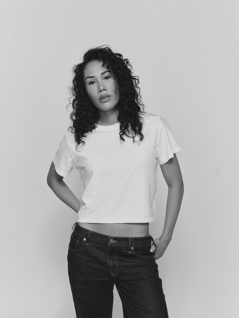 Model wearing the Saint Sirène Girlfriend Tee in white with dark denim jeans.