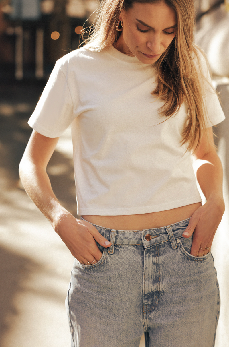 Close-up of a woman wearing a Saint Sirène white t-shirt and jeans.