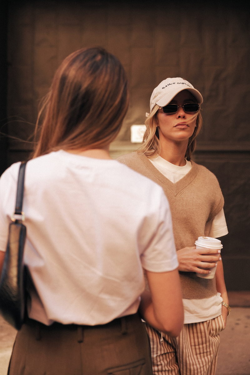 Two women wearing Saint Sirène white t-shirts in a city setting.